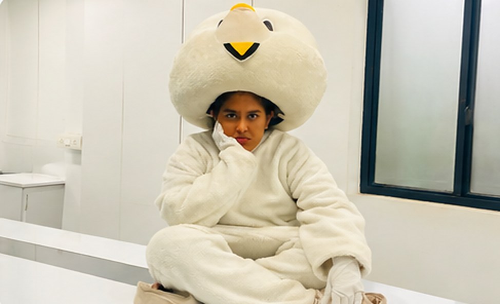 A team member in the rabbit mascot costume, sitting in the office